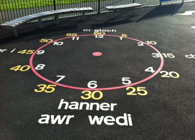 welsh clock with hours, minutes and text playground markings in Caerphilly